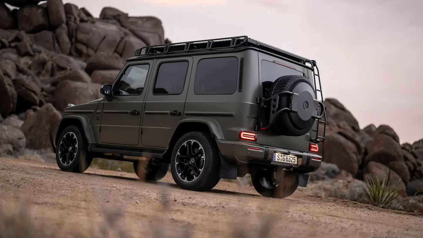 Olive Mercedes-AMG G 63 among desert boulders, seen from the rear